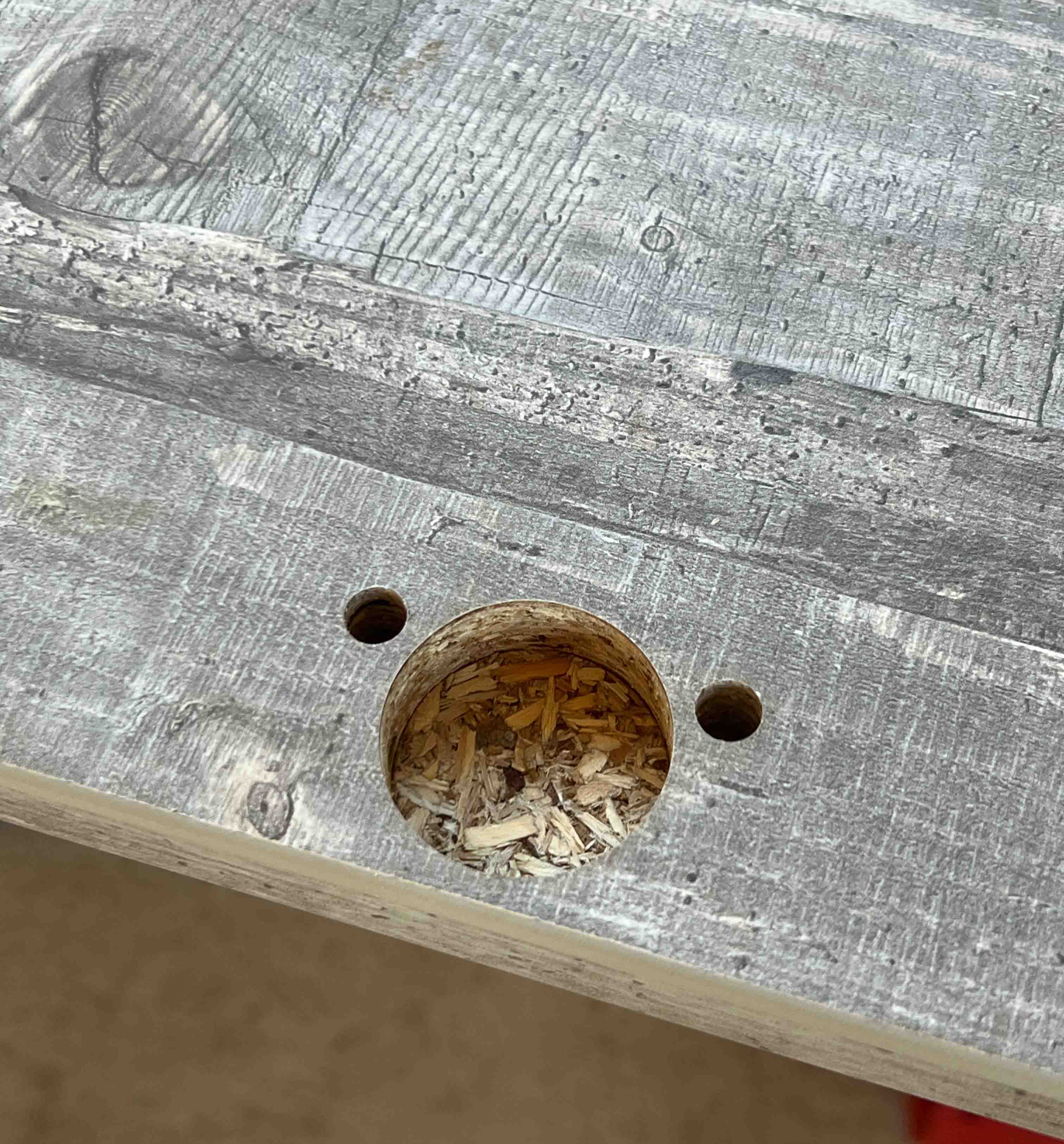 Bild zeigt Topfbandbohrung an einer Dekorspanplatte mit Kante.